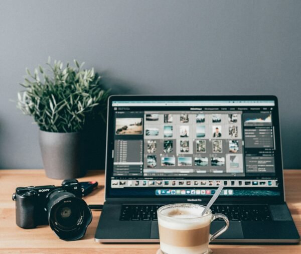 black laptop computer beside white ceramic mug on brown wooden table