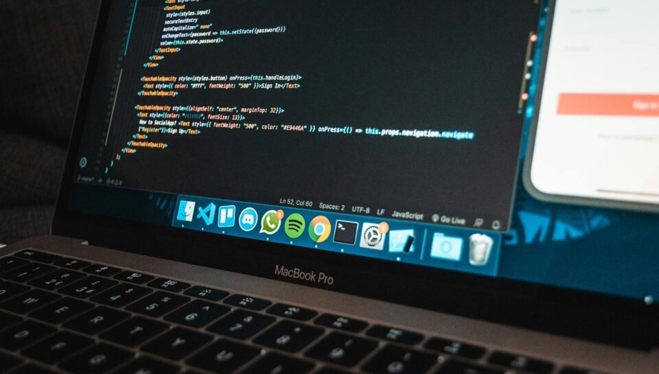 workplace with modern laptop with program code on screen